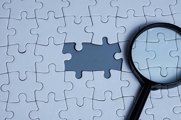 istock A magnifying glass placed on a white puzzle with a puzzle gap 2250541432