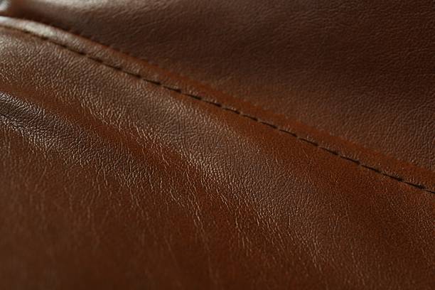 istock Brown leather with seam as background, closeup 2250542532