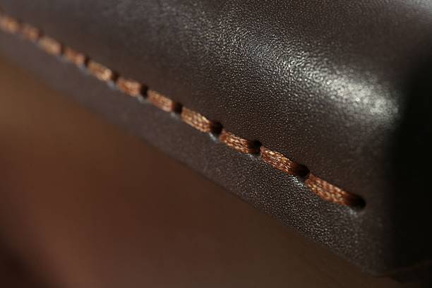 istock Dark leather with brown seam as background, closeup 2250542650