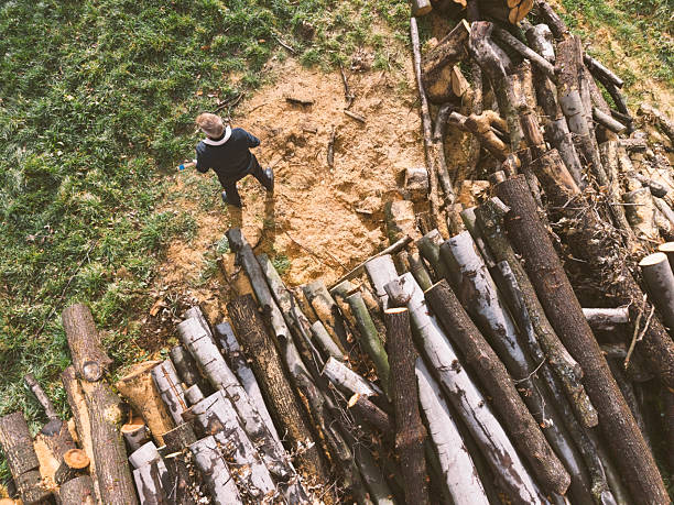 Man with axe prepare to chop timber for firewood in his backyard, prepare for winter