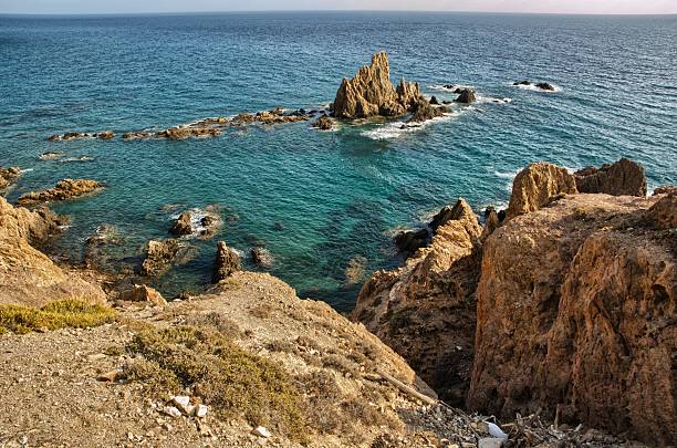 This photo was taken on October 9, 2025. Located in Cabo de Gata, it corresponds to the Mirador de las Sirenas (Mermaids' Lookout). It is actually the remains of an ancient volcanic chimney. It gets its name from the presence of a colony of monk seals that local fishermen called mermaids or sea wolves. This mammal inhabited the Cabo de Gata coast until the mid-20th century. It is currently endangered throughout the Mediterranean.