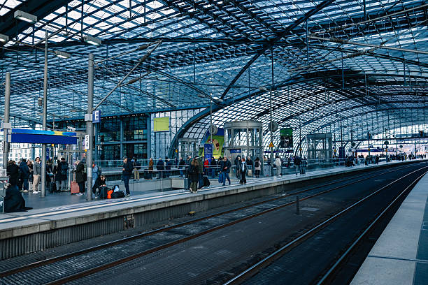 Wide view of a busy railway hub filled with passengers using public mass transit in a real daily travel moment.