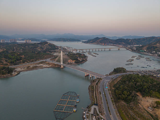 istock Aerial View of a Modern Bridge Spanning a River at Dusk 2250556982
