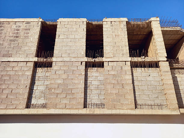 istock View from below of a building facade under construction. Wall and pillars of a building under construction under a blue sky. Construction and Architecture 2250563640