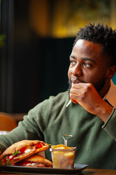 istock Young Black man eating breakfast in cafe 2250566058