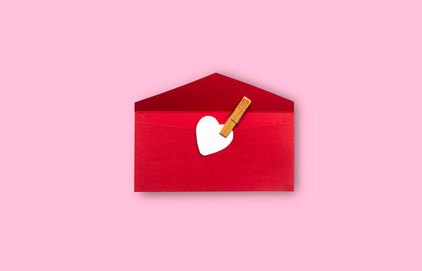 Valentine's Day love letter.\nRed and white colored envelope on red background.