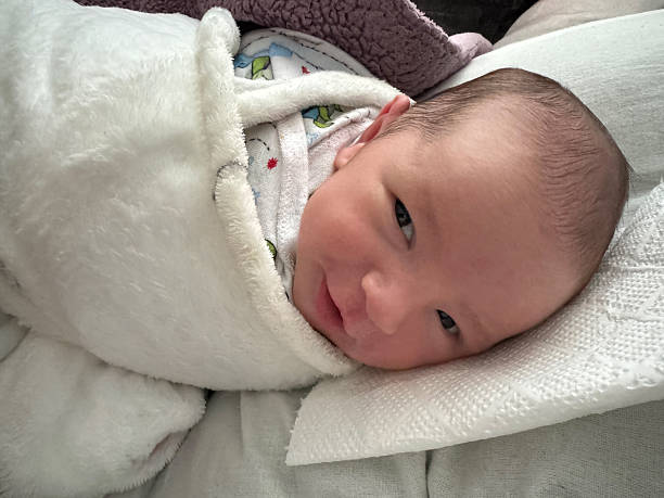 istock Newborn Baby Awake and Looking Curious While Swaddled in Blanket 2250570138