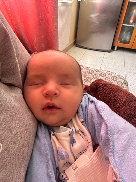 istock Sleeping Newborn Baby Wrapped in Blanket at Home 2250570431
