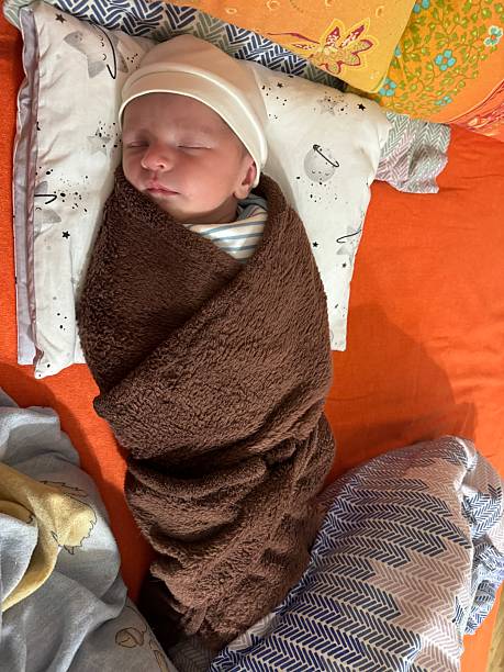 istock Peaceful Newborn Baby Sleeping Wrapped in Brown Blanket 2250570647