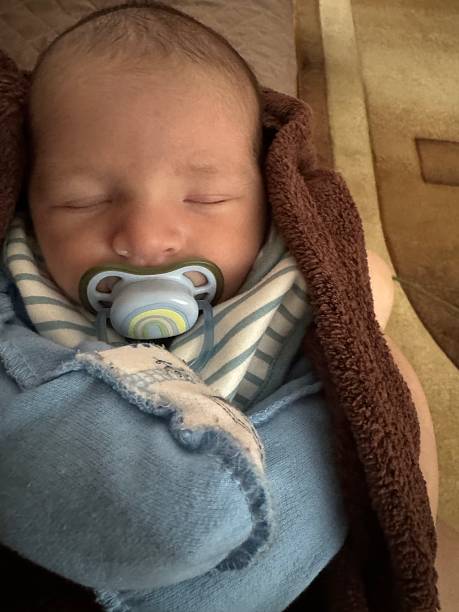 istock Sleeping Newborn Baby with Pacifier Wrapped in Soft Blanket 2250570744