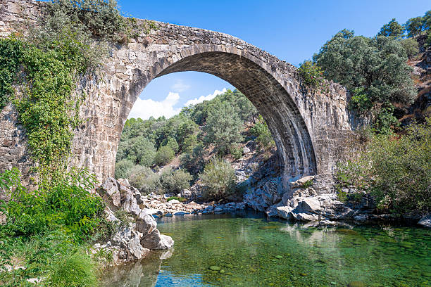 Imposing, high, historic, monumental Roman stone bridge structure.