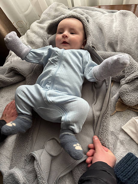 istock Playful Newborn Baby Moving Legs While Lying on Blanket Indoors 2250571465