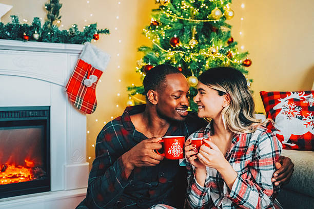 istock Romantic couple drinking hot chocolate by the fireplace 2250573944