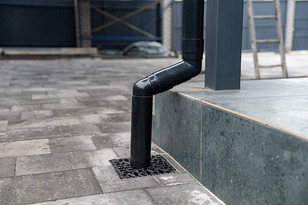 istock Black gutter system downspout connecting to ground drainage grate 2250578592