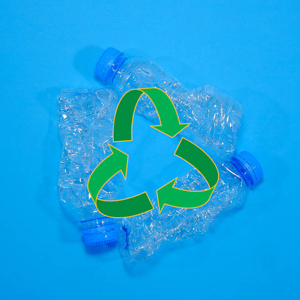 istock Three empty clear plastic water bottles together around a vibrant green recycling symbol on a blue background promoting sustainability efforts 2250580307
