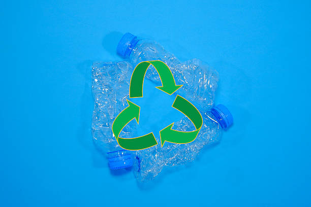 istock Three empty clear plastic water bottles together around a vibrant green recycling symbol on a blue background promoting sustainability efforts 2250581023