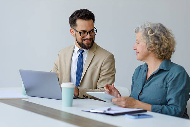 istock Professional business people collaborating in office meeting discussing project using laptop and digital tablet 2250582555