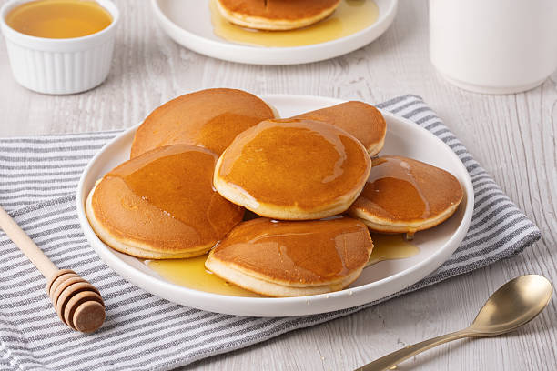 istock Delicious fluffy pancakes with syrup served on a white plate for breakfast 2250587121