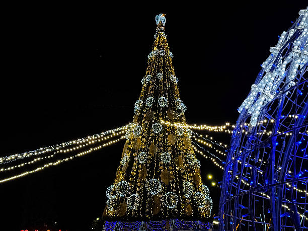 istock Large Christmas tree and glowing light sphere in a festive outdoor display at night, with decorative LEDs 2250590149