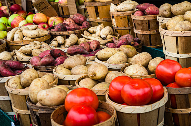 Baskets of fresh tomatoes, potatoes, sweet potatoes and apples offered for sale at a Lancaster County, Pennsylvania farmers'  market.