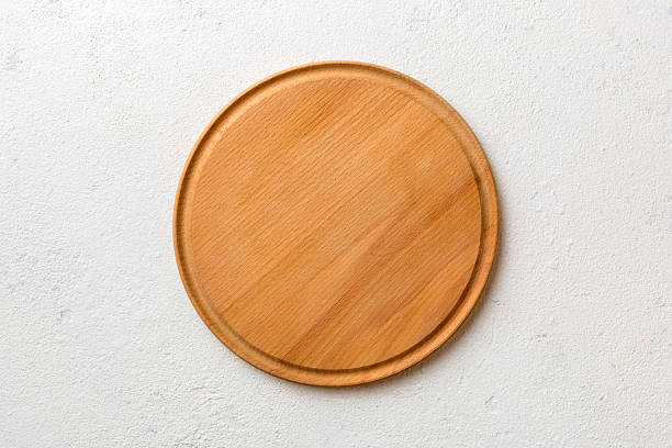 istock Top view of wooden cutting board on cement background. Empty space for your design 2250591276