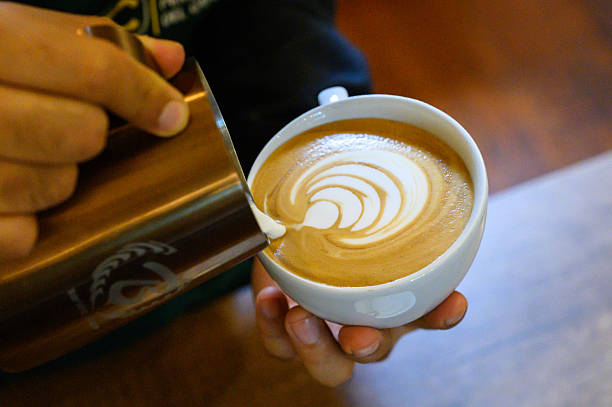 istock Barista pouring milk creating latte art in coffee cup 2250599846