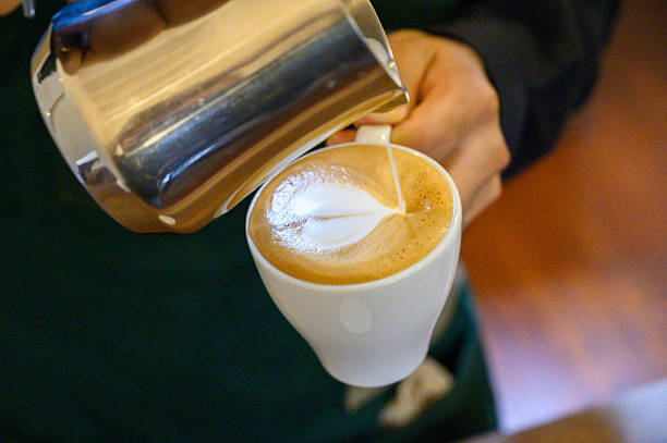 istock Barista making latte art pouring milk into coffee 2250600376
