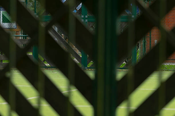 this picture is a Soccer Goal and Soccer Net on Soccer Field during Soccer Game. the lawn is green grass or artificial turf. the lighting is natural lighting with sunlight during the day or evening. this was taken at a sporting event. 
