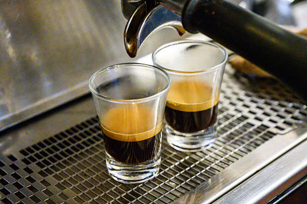Espresso machine brewing two espresso shots into small glass cups