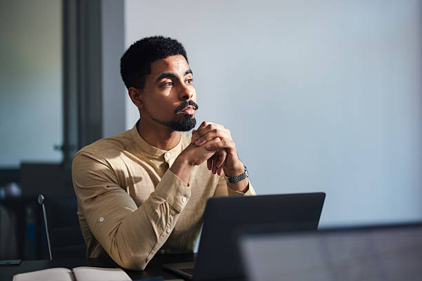 istock Thoughtful Business Professional At Desk With Laptop In Modern Office Setting 2250601287