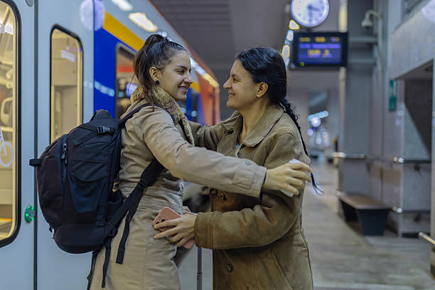 istock Mother and daughter embracing at train station goodbye 2250605023
