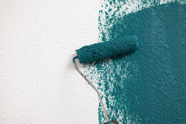istock Paint roller applying teal paint on textured wall, showcasing vibrant color contrast and artistic home improvement concept with copy space 2250606869