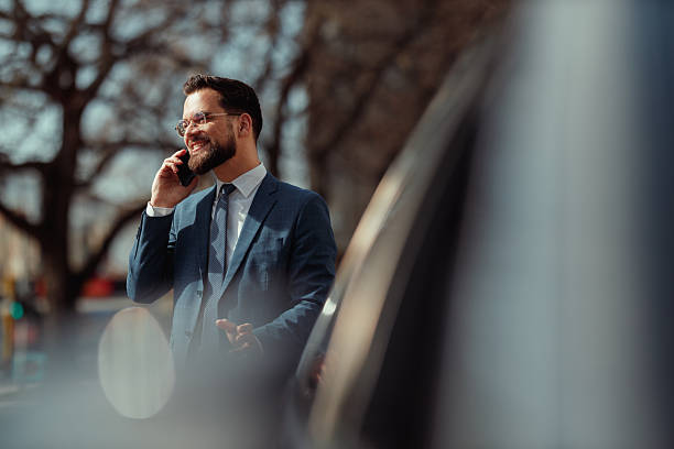 istock Businessman Talking on Phone by Car 2250614539