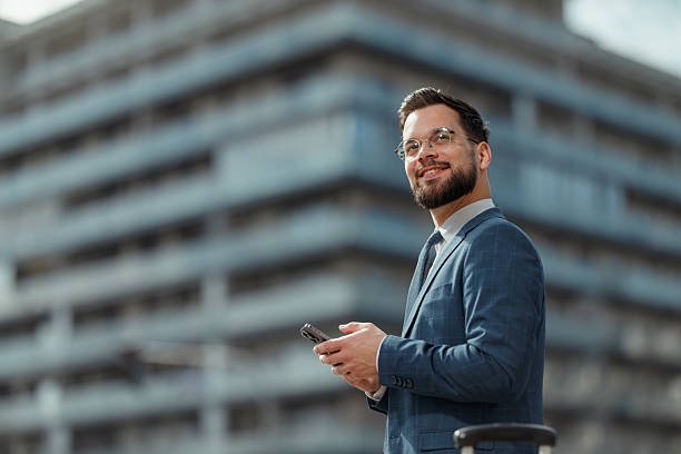 istock Smiling Businessman Using Smartphone Outdoors 2250614552