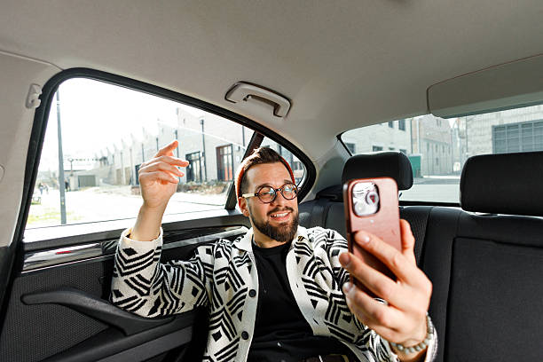 istock Man Having Video Call in Car Backseat 2250614561