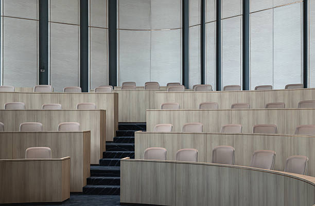 istock A distinctly modern, minimalist auditorium, characterized by its clean aesthetic, features curved, tiered seating, making it an ideal venue for focused presentations or meetings. 2250615253