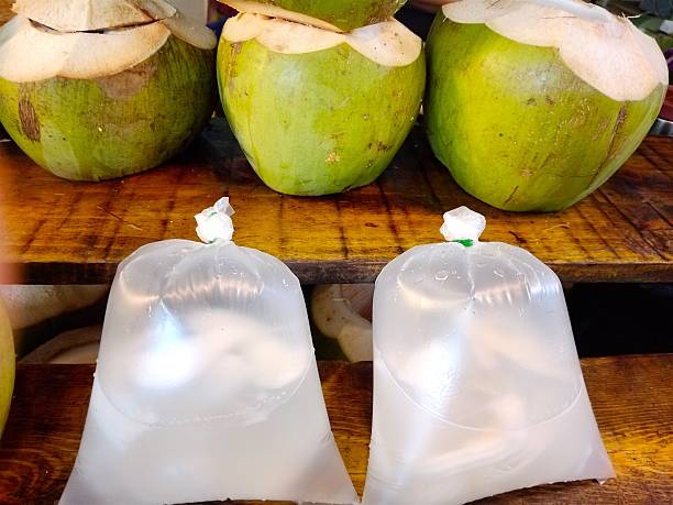 istock Fresh Coconut Water Bagged Beside Green Coconuts 2250615739