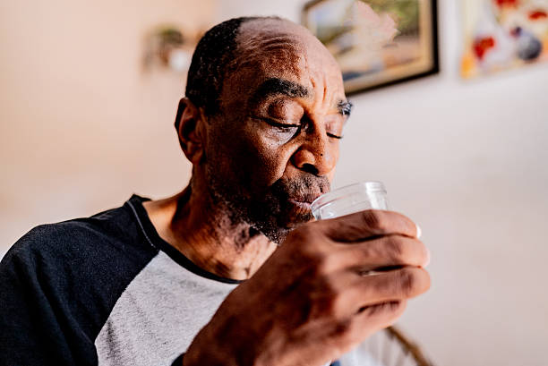 istock Senior man drinking water at home 2250617296