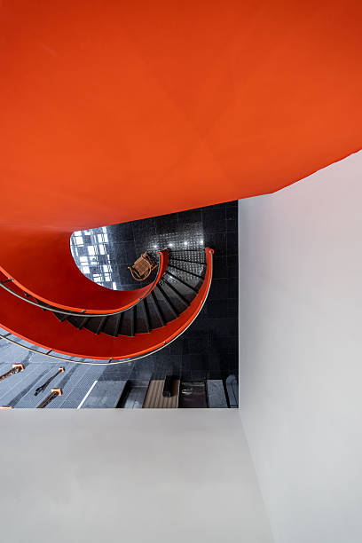 The interior features a red spiral staircase handrail and black steps.