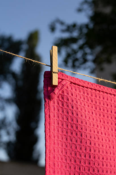 istock Colorful textile towels hanging on a clothesline outdoors. Freshly washed fabric drying in natural sunlight with clothespins, soft texture, summer atmosphere, eco-friendly laundry concept. 2250621738