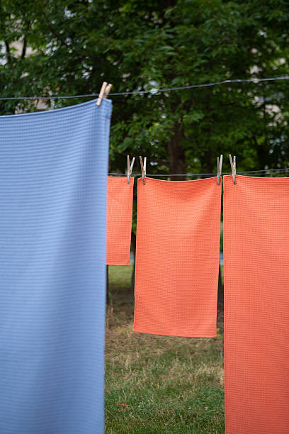 istock Colorful textile towels hanging on a clothesline outdoors. Freshly washed fabric drying in natural sunlight with clothespins, soft texture, summer atmosphere, eco-friendly laundry concept. 2250621805