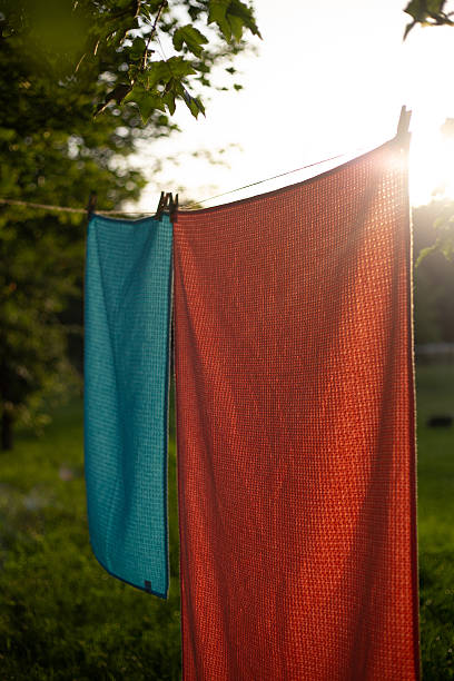 istock Colorful textile towels hanging on a clothesline outdoors. Freshly washed fabric drying in natural sunlight with clothespins, soft texture, summer atmosphere, eco-friendly laundry concept. 2250622239