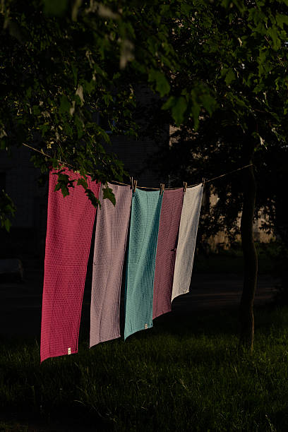 istock Colorful textile towels hanging on a clothesline outdoors. Freshly washed fabric drying in natural sunlight with clothespins, soft texture, summer atmosphere, eco-friendly laundry concept. 2250622249
