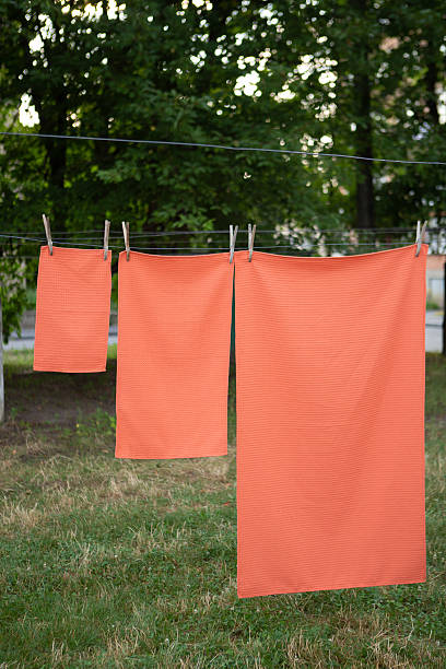 istock Colorful textile towels hanging on a clothesline outdoors. Freshly washed fabric drying in natural sunlight with clothespins, soft texture, summer atmosphere, eco-friendly laundry concept. 2250622261