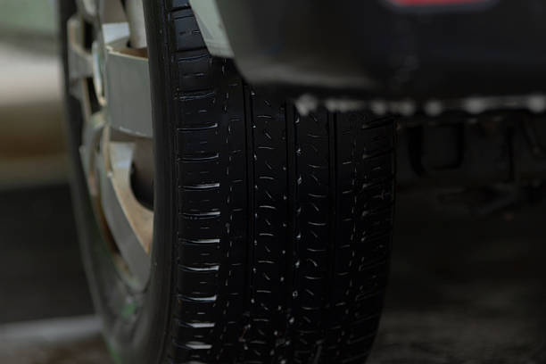 Mudrubber tracks, Soaked tire tread revealing prominent ridges and firm grip features, Watercovered tire pattern exhibiting intense grooves and powerful traction design under illumination