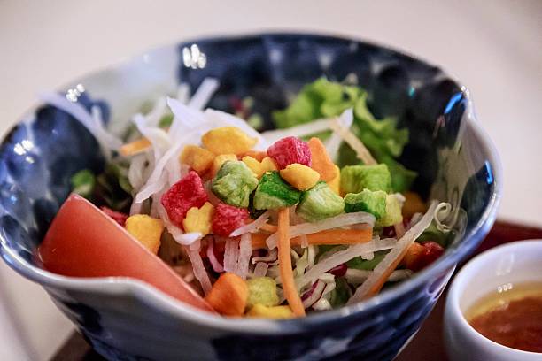 Fresh Garden Salad with Shredded Daikon, Carrot, and Colorful Vegetable Croutons in a Blue Patterned Ceramic Bowl