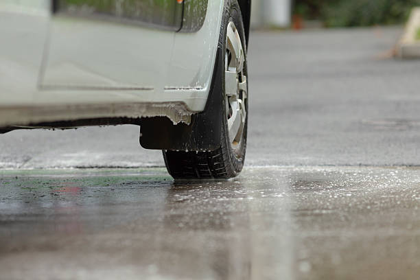 istock Vehicle rear wheel creating spray on slick asphalt surface during rain 2250626659