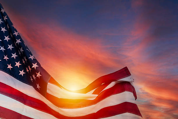 istock American flag waving with sunlight glowing through stripes against dramatic colorful sky symbolizing pride and freedom 2250633194