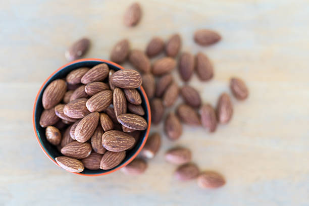 Close up of organic peeled almond nuts in cup