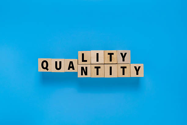 istock wooden blocks with quality and quantity words. isolated on blue background 2250640503